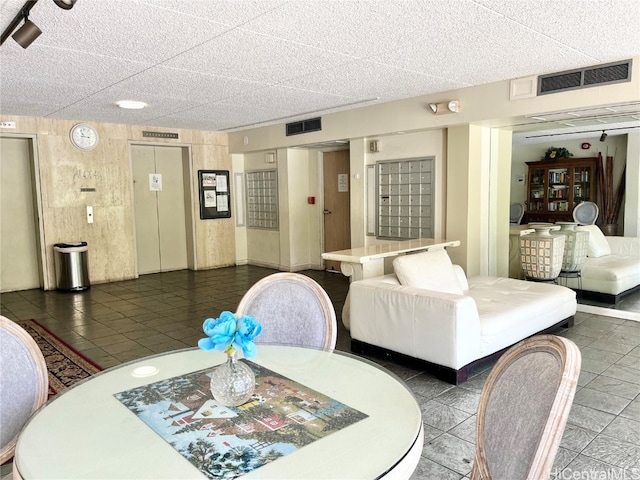 dining area with dark tile patterned floors and a mail area