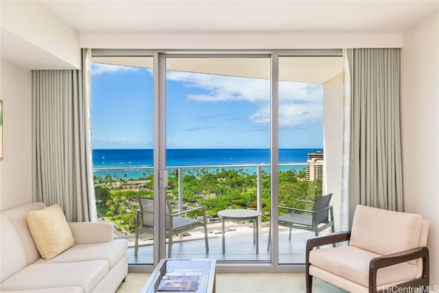 entryway with a water view, light colored carpet, and plenty of natural light