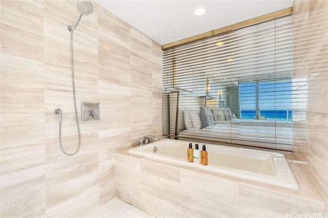 bathroom with shower with separate bathtub and tile walls