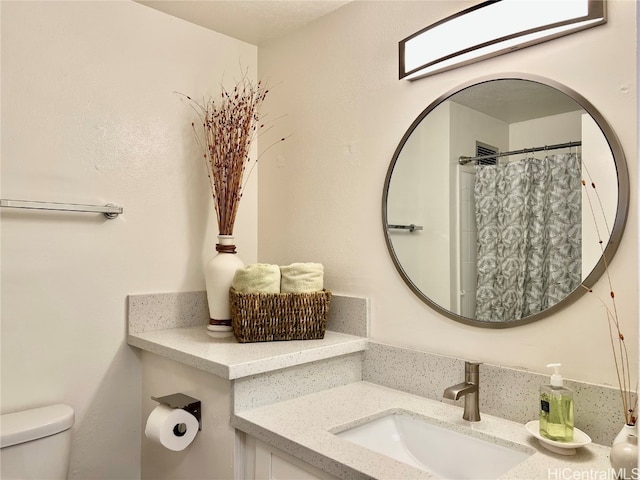 bathroom with toilet, curtained shower, and vanity