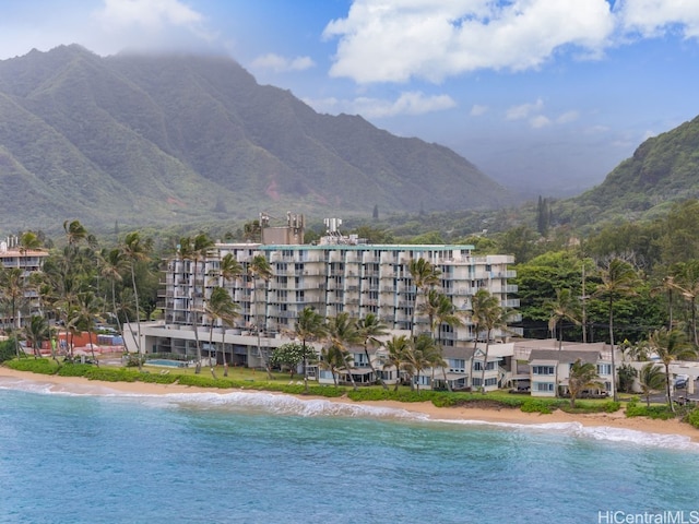 view of swimming pool with a water and mountain view and a beach view