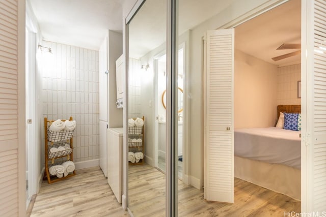 bathroom featuring hardwood / wood-style floors, tile walls, and ceiling fan