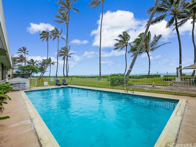 view of swimming pool featuring a patio and a yard