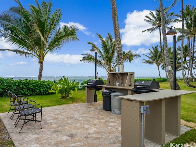 view of patio with area for grilling and a water view