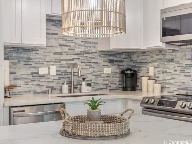 kitchen featuring appliances with stainless steel finishes, white cabinets, and sink