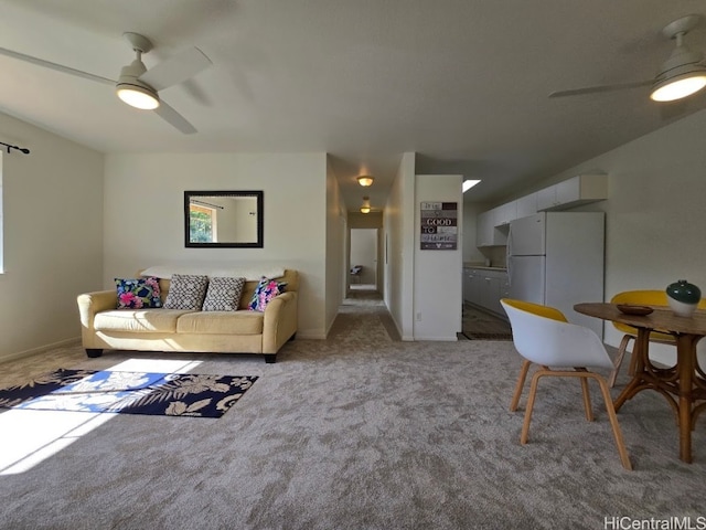 carpeted living area featuring baseboards and ceiling fan