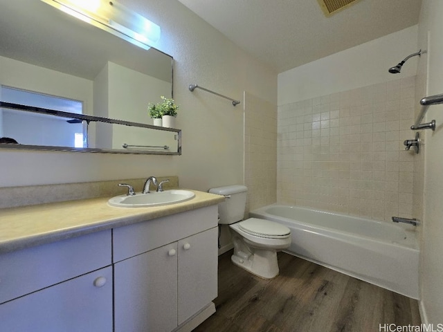 full bathroom featuring vanity, toilet, tiled shower / bath combo, and wood-type flooring