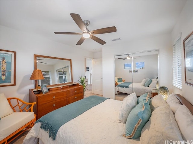 bedroom with multiple windows, ceiling fan, and a closet