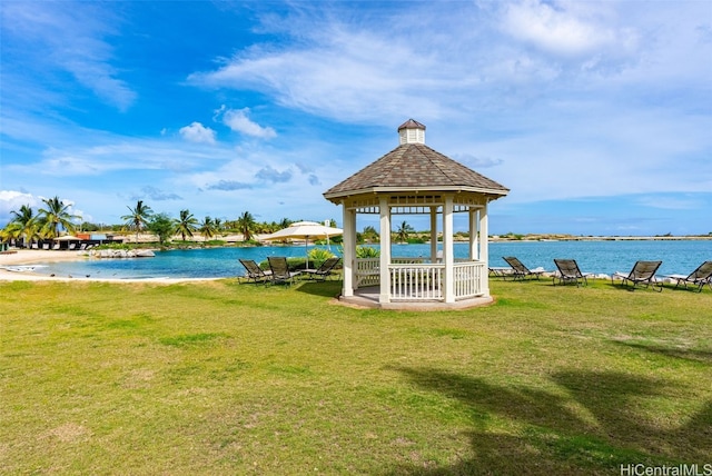 surrounding community with a gazebo, a lawn, and a water view