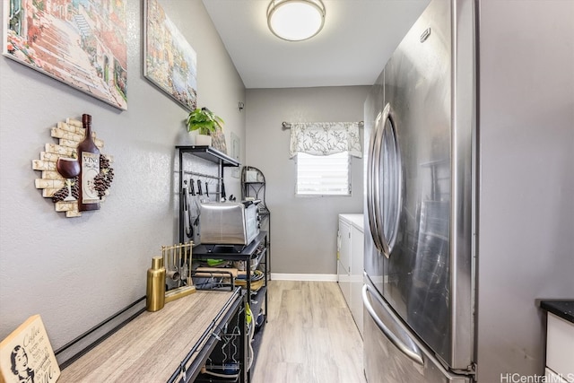 kitchen with stainless steel fridge and light hardwood / wood-style flooring