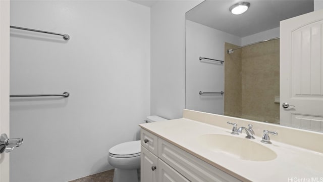 bathroom featuring vanity, a tile shower, and toilet