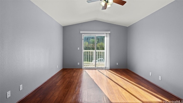 empty room featuring dark wood-type flooring, vaulted ceiling, and ceiling fan