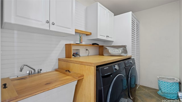 laundry room with cabinets, dark tile patterned floors, and washer and clothes dryer