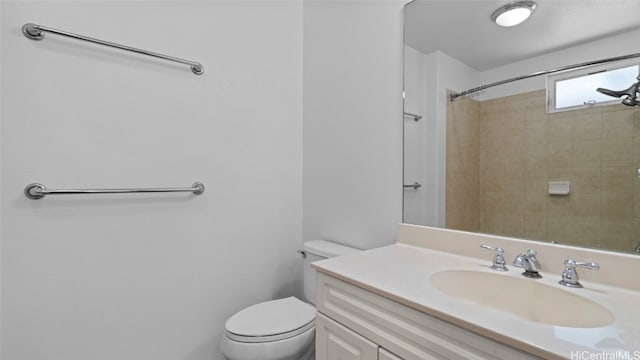 bathroom featuring vanity, toilet, and a tile shower