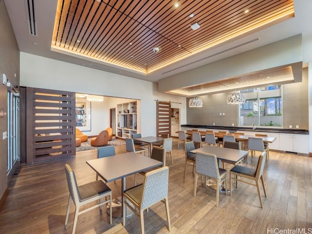 dining area featuring hardwood / wood-style flooring, a tray ceiling, and wood ceiling