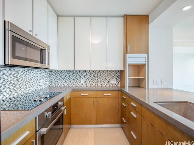 kitchen featuring white cabinets, decorative backsplash, sink, and appliances with stainless steel finishes