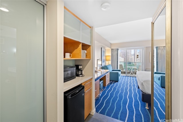 interior space featuring black appliances and dark carpet