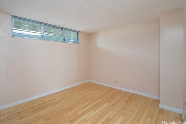 unfurnished room with light hardwood / wood-style floors and a textured ceiling