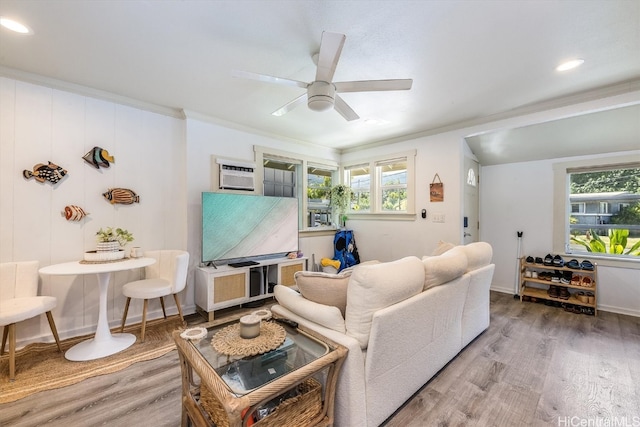 living room with ornamental molding, wood-type flooring, plenty of natural light, and ceiling fan