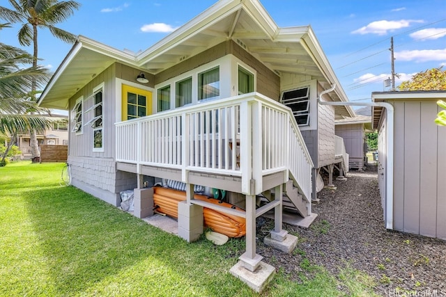 back of property with a deck and a lawn