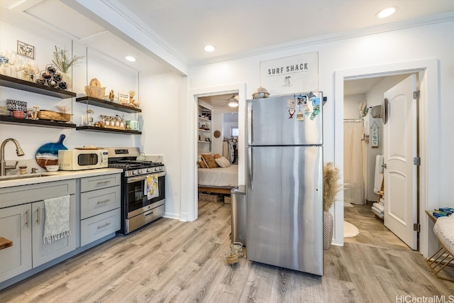 kitchen featuring crown molding, stainless steel appliances, sink, and light wood-type flooring