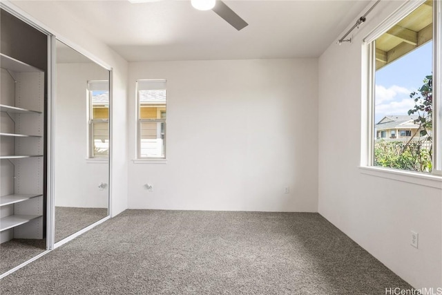 unfurnished bedroom featuring carpet floors, ceiling fan, and a closet