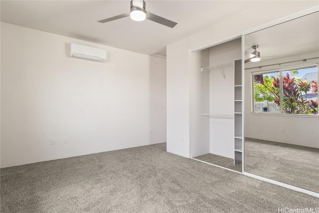 unfurnished bedroom with a wall unit AC, ceiling fan, a closet, and carpet