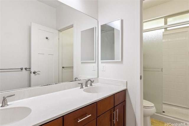 bathroom featuring toilet, an enclosed shower, and vanity