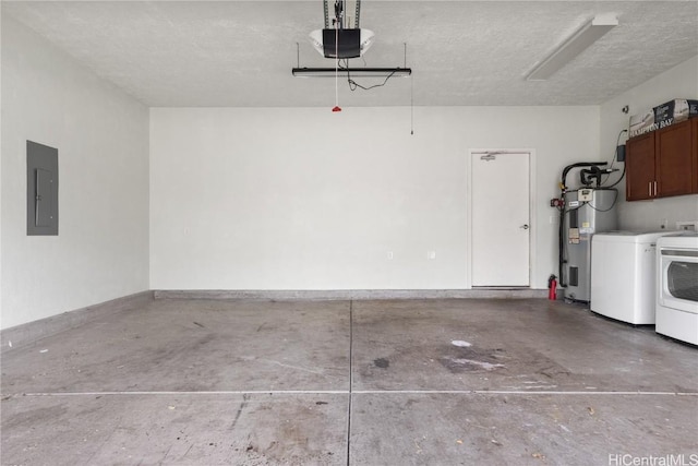 garage featuring a garage door opener, water heater, electric panel, and independent washer and dryer