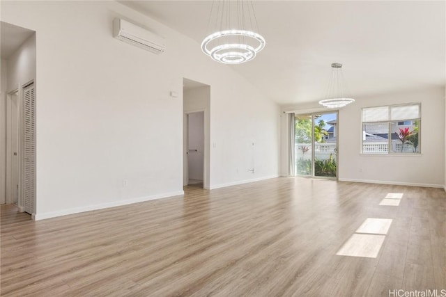 unfurnished living room with vaulted ceiling, a wall mounted air conditioner, a chandelier, and light hardwood / wood-style flooring