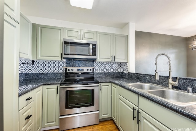 kitchen featuring light hardwood / wood-style flooring, stainless steel appliances, sink, and backsplash