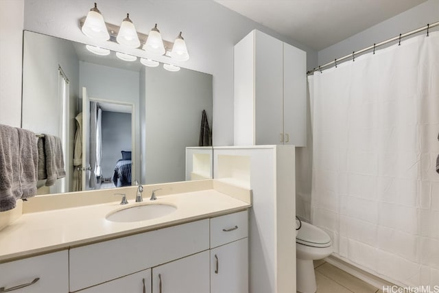 bathroom with tile patterned flooring, vanity, and toilet