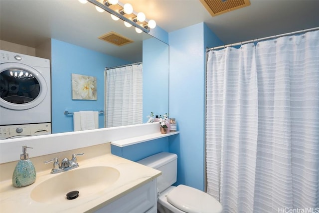 bathroom featuring a shower with curtain, vanity, stacked washer and dryer, and toilet