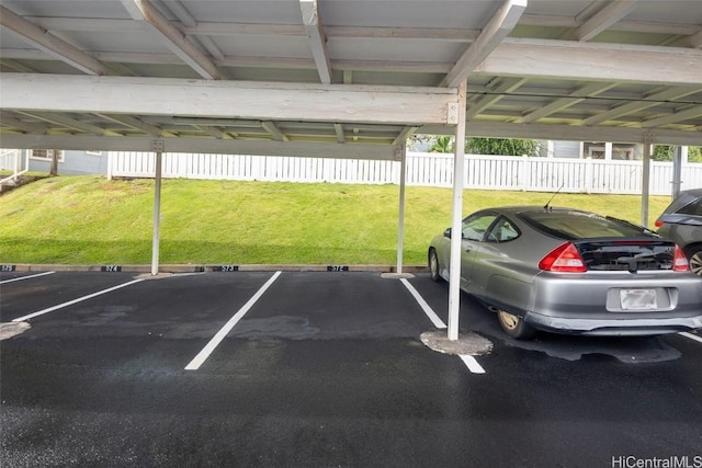 view of parking with a lawn and a carport