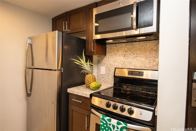 kitchen featuring dark brown cabinets, stainless steel appliances, and tasteful backsplash