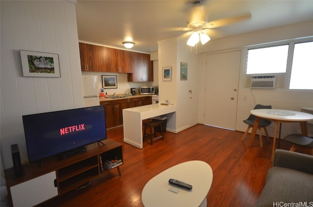 living room featuring ceiling fan, cooling unit, sink, and dark hardwood / wood-style floors