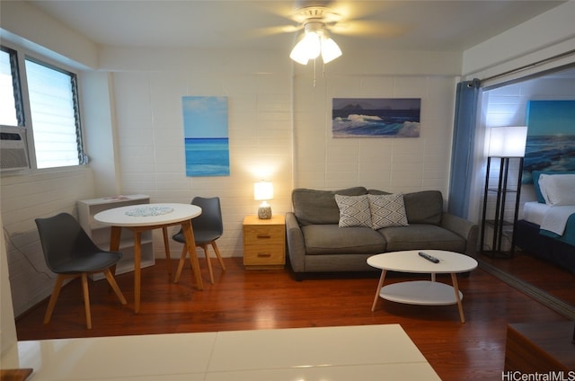 living room with ceiling fan and dark hardwood / wood-style flooring