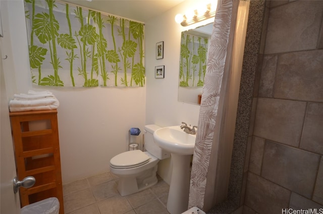 bathroom with sink, toilet, and tile patterned flooring