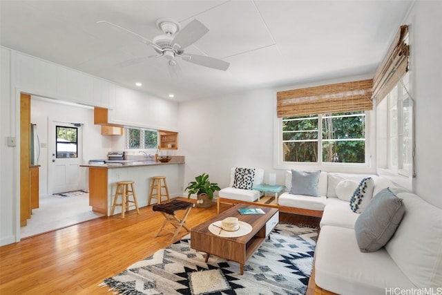 living room featuring light hardwood / wood-style floors and ceiling fan