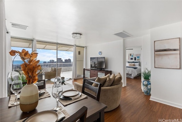 dining area with visible vents, baseboards, and wood finished floors