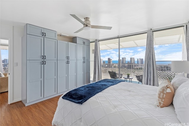 bedroom with ceiling fan, light hardwood / wood-style floors, multiple windows, and access to outside