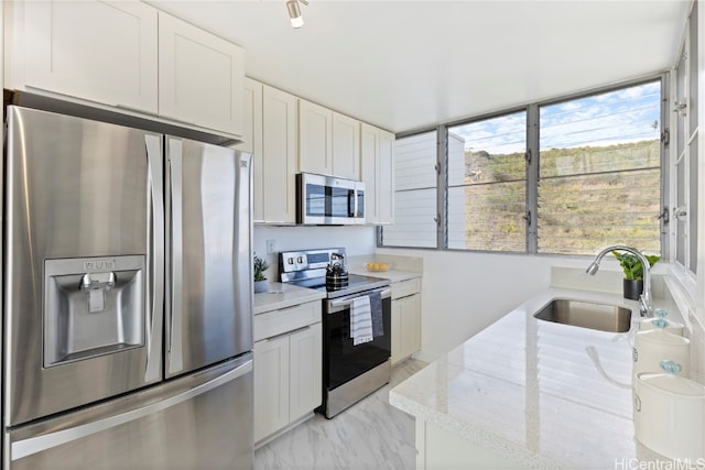 kitchen featuring light stone countertops, sink, white cabinetry, and stainless steel appliances