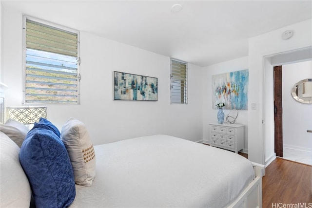 bedroom featuring baseboards and wood finished floors