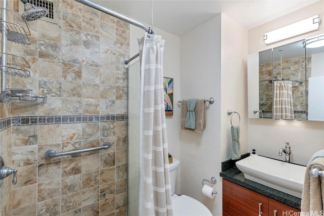 bathroom with a shower stall, toilet, and vanity