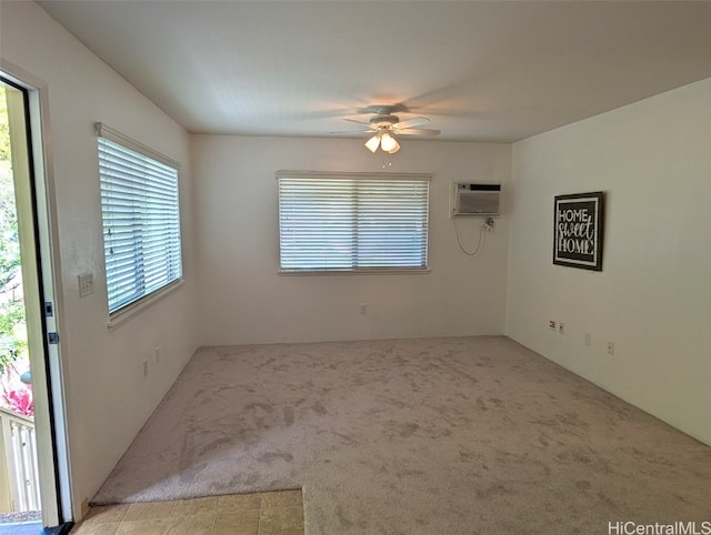 empty room with light carpet, ceiling fan, a wall mounted air conditioner, and a wealth of natural light