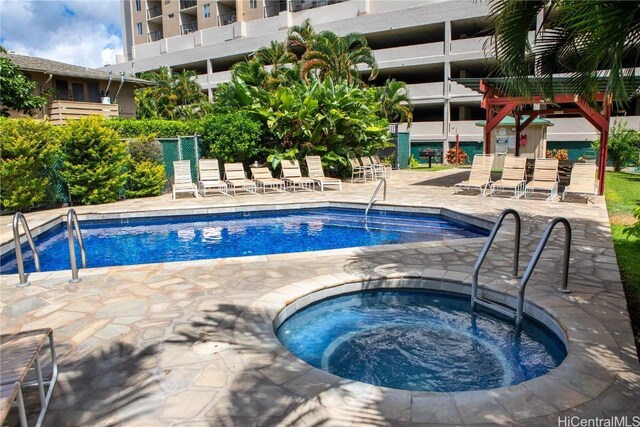 view of swimming pool featuring a patio area and a hot tub