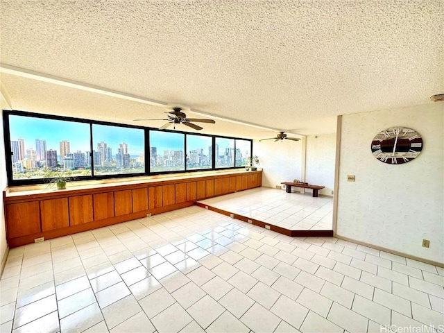 tiled empty room featuring a textured ceiling