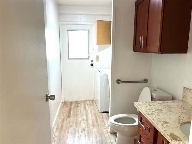 bathroom featuring washer / dryer, toilet, wood-type flooring, and vanity