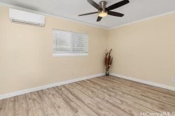 empty room featuring crown molding, light hardwood / wood-style flooring, and a wall mounted air conditioner