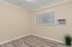 unfurnished room with crown molding, a wall unit AC, and hardwood / wood-style flooring